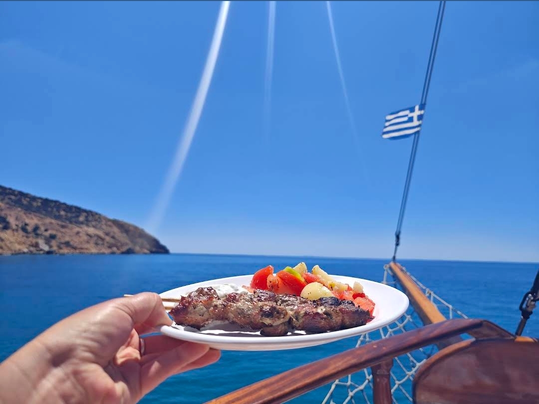 Ελληνικό BBQ — σουβλάκι στο σκάφος Ιάσων με ελληνική σημαία και θέα στη θάλασσα